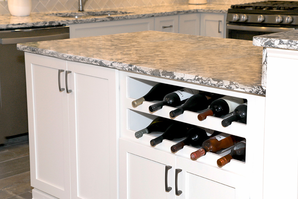 An open concept island with wine rack and pull out drawers replaces the outdated peninsula layout.