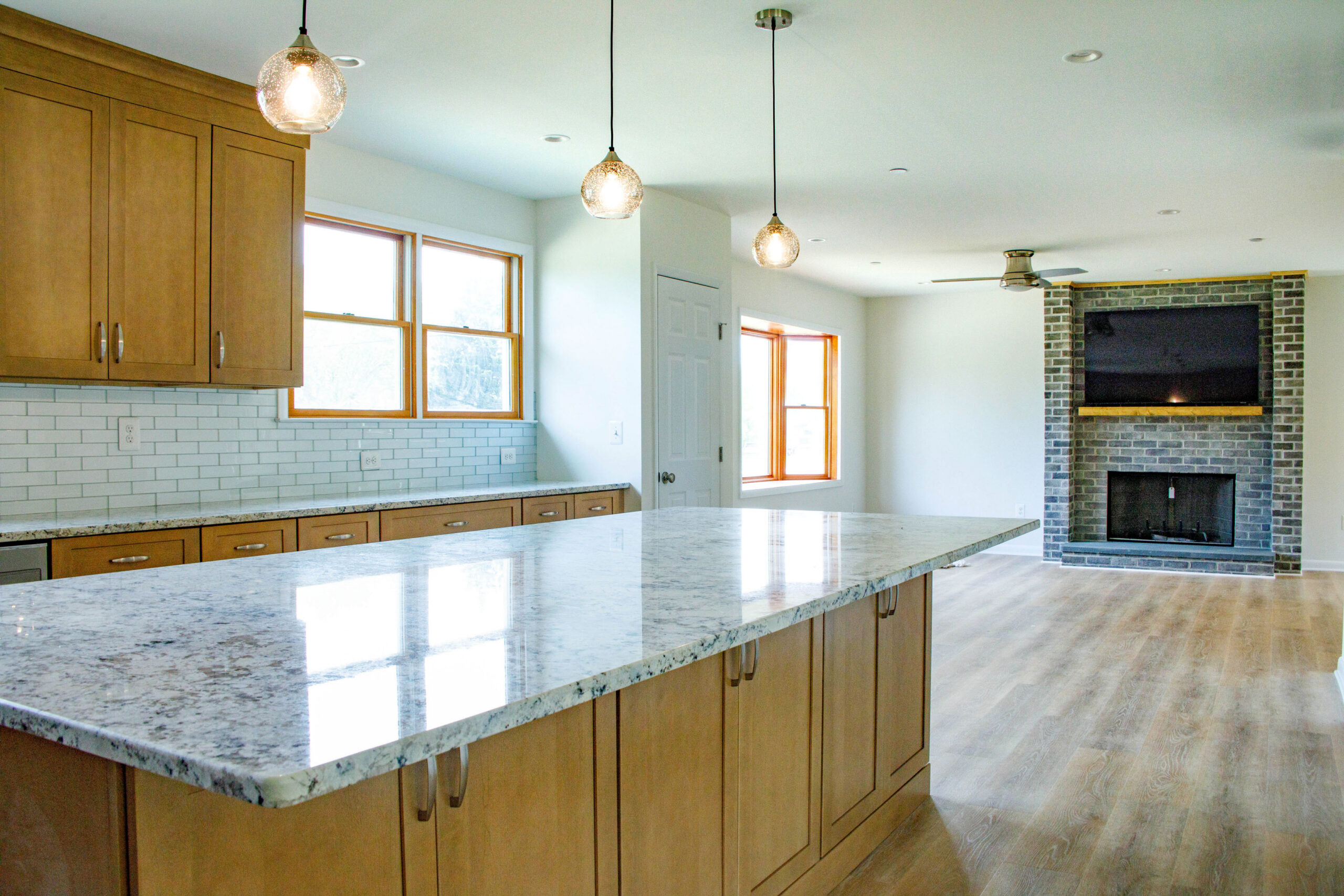 subway tiles and warm wood link the open concept kitchen and living room